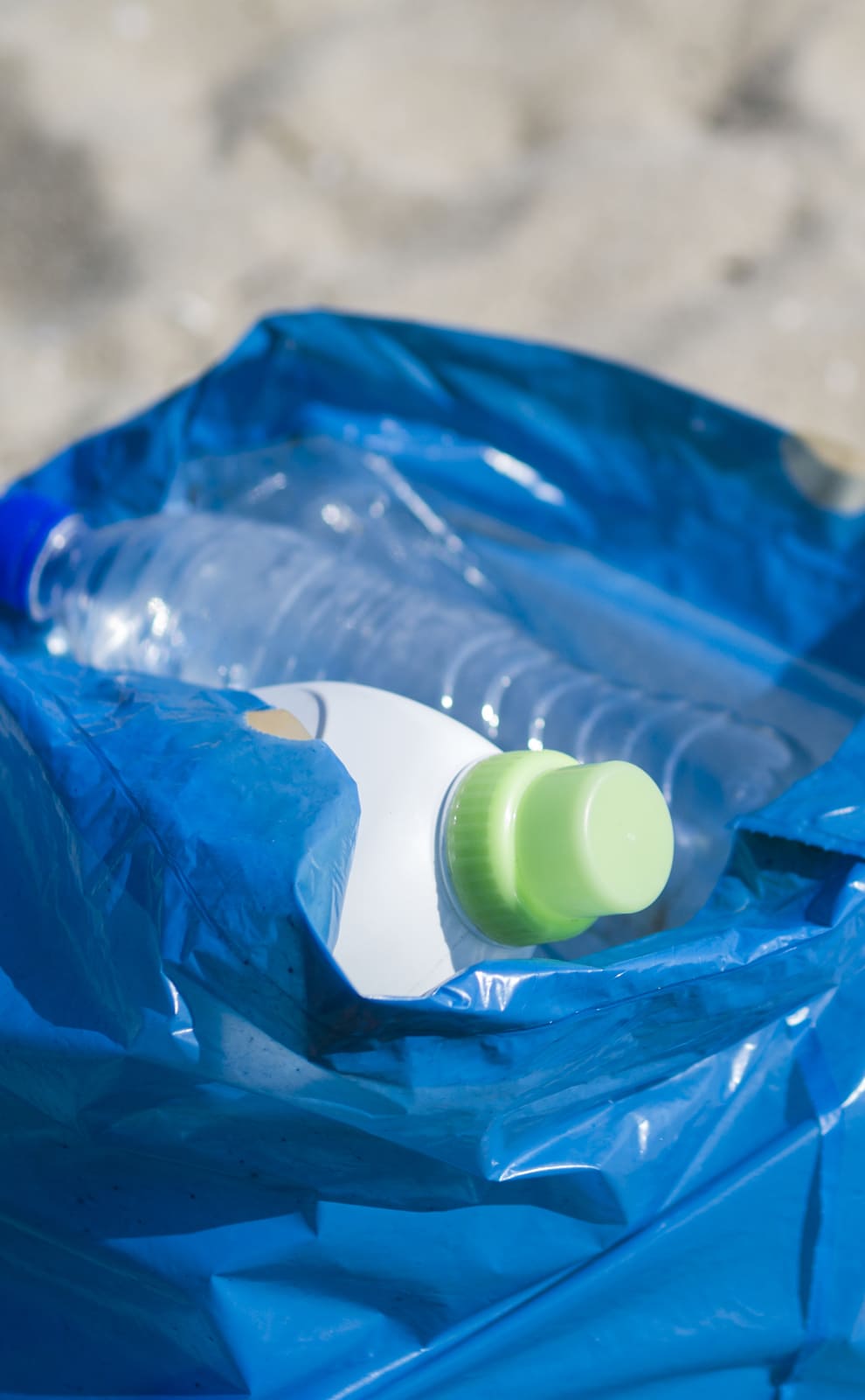 Déchets contenus dans un sac posé sur le sable